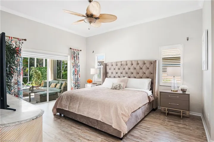 Bedroom with ornamental molding, multiple windows, access to outside, and light wood-style flooring