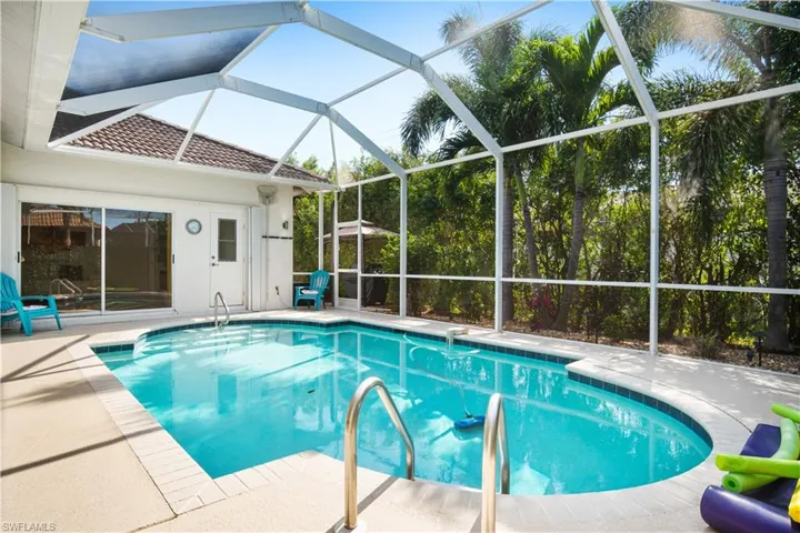 Swimming pool featuring a patio, a sunroom, and glass enclosure
