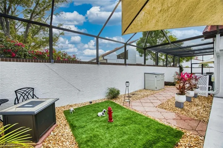 Fenced backyard with a sunroom, glass enclosure, and a patio area