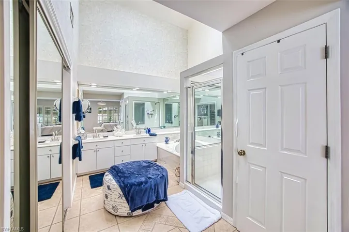 Full bathroom featuring vanity, light tile patterned flooring, and a garden tub