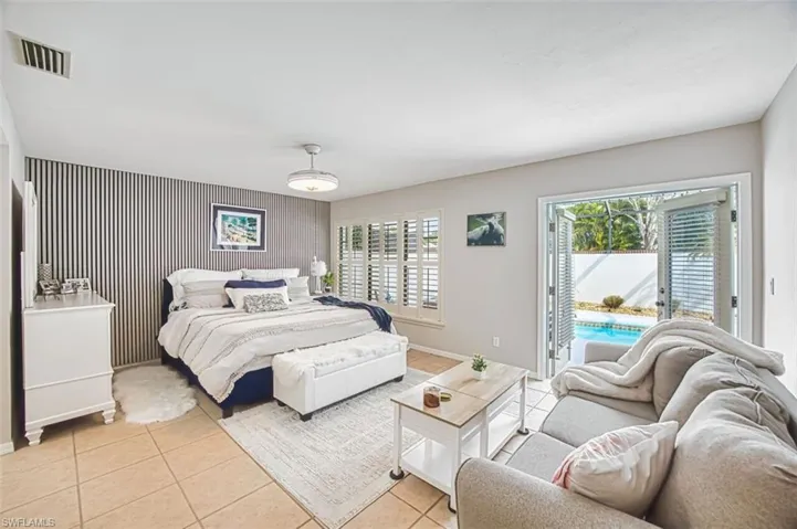 Bedroom with an accent wall, access to exterior, and tile patterned floors