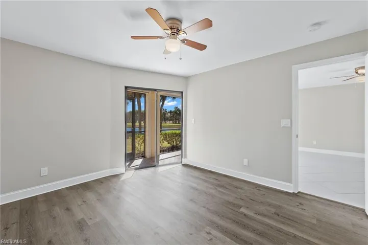 Empty room with a ceiling fan and wood finished floors