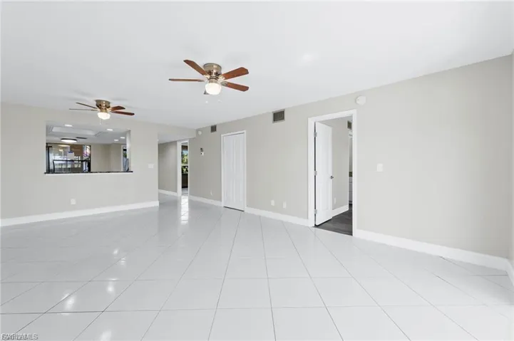 Unfurnished living room with ceiling fan and light tile patterned flooring