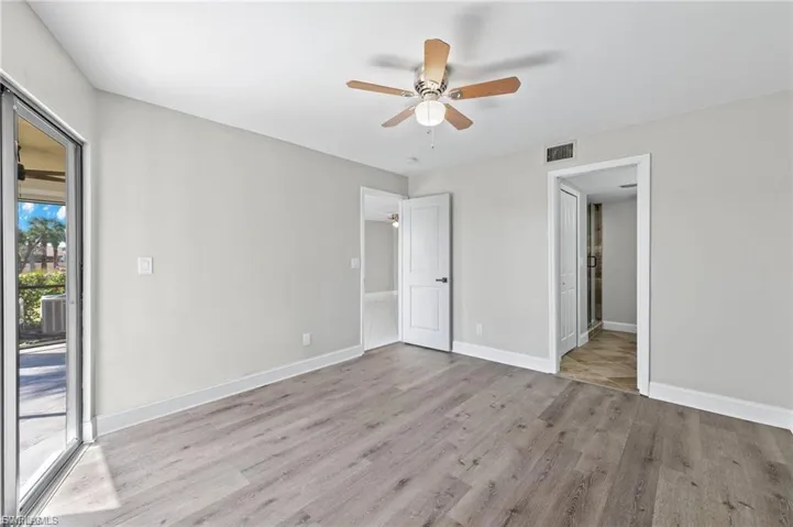 Unfurnished bedroom with light wood-style flooring, access to exterior, and a ceiling fan