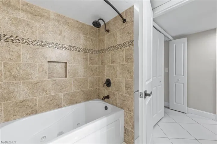 Bathroom featuring a combined bath / shower with jetted tub and light tile patterned floors