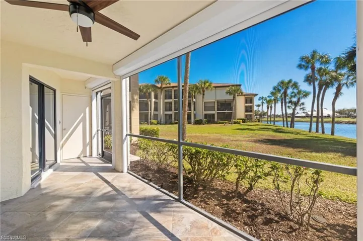 Unfurnished sunroom featuring ceiling fan and a water view