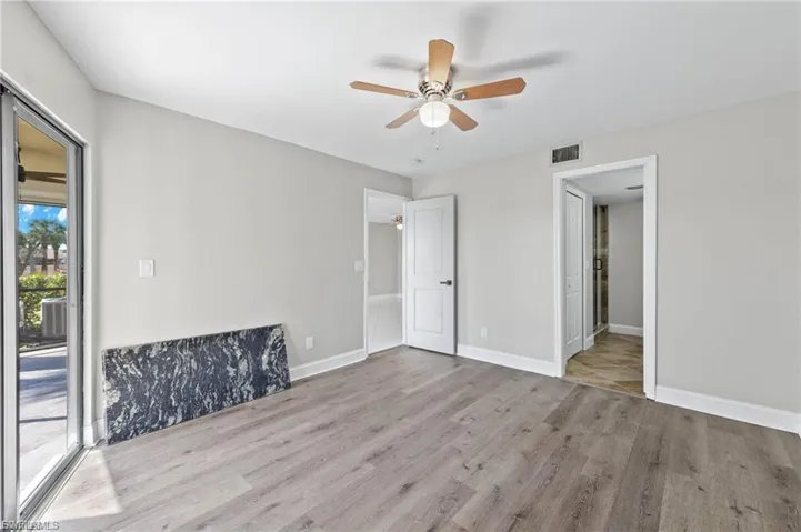Unfurnished bedroom with light wood-style flooring, access to outside, and ceiling fan