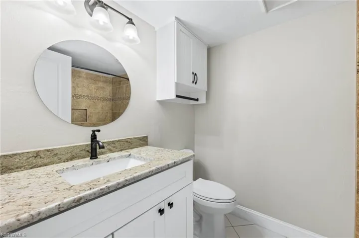 Full bath featuring vanity, light tile patterned flooring, and a tile shower