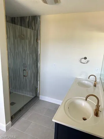 Master bathroom featuring vanity, tile patterned floors, and walk in shower