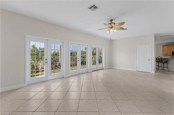 Family room featuring french doors (great water views!), ceiling fan, and light tile patterned floors