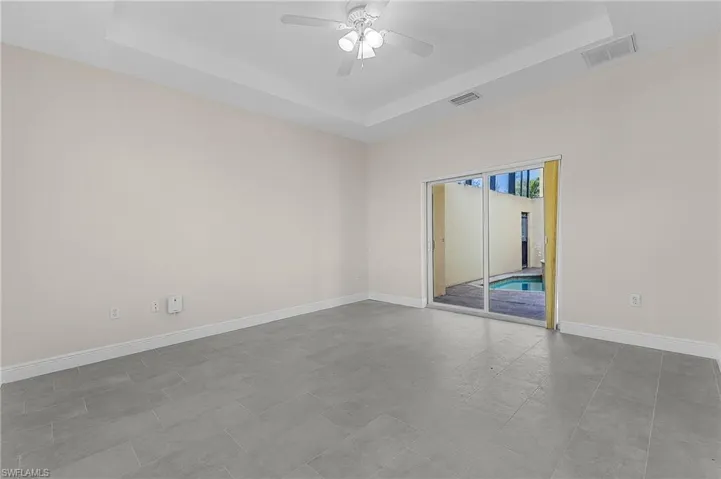 Cabana bedroom with pool access! Tile floors with ceiling fan and a raised ceiling