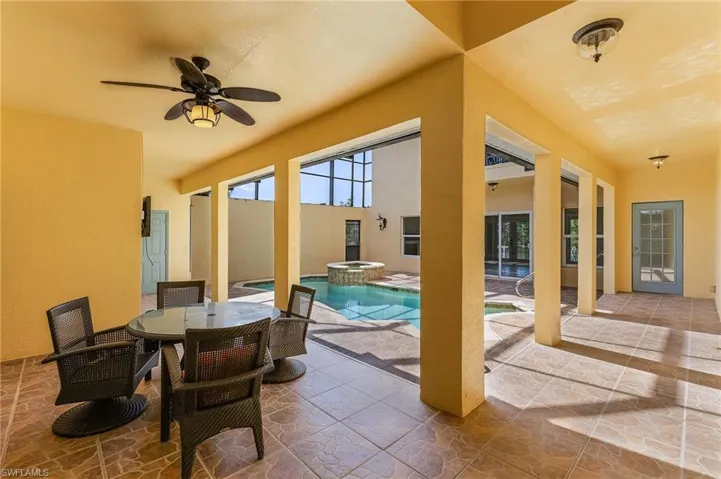 View of heated, salt system pool featuring a patio area, ceiling fan, and an in ground hot tub