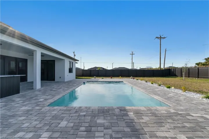View of swimming pool with a patio and a lawn