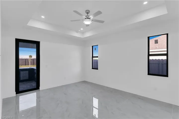 Empty room with a raised ceiling and ceiling fan