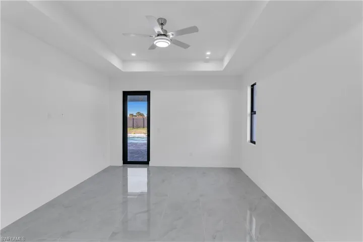 Spare room featuring ceiling fan and a tray ceiling