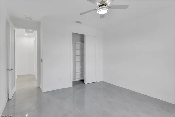 Unfurnished bedroom featuring ceiling fan and a closet