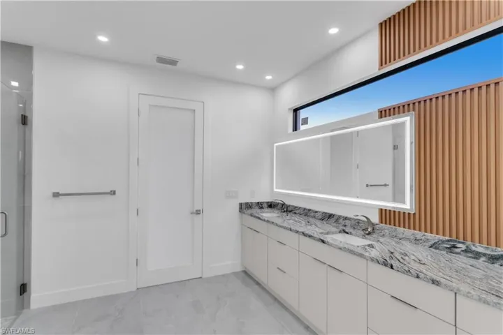 Bathroom featuring an enclosed shower and vanity