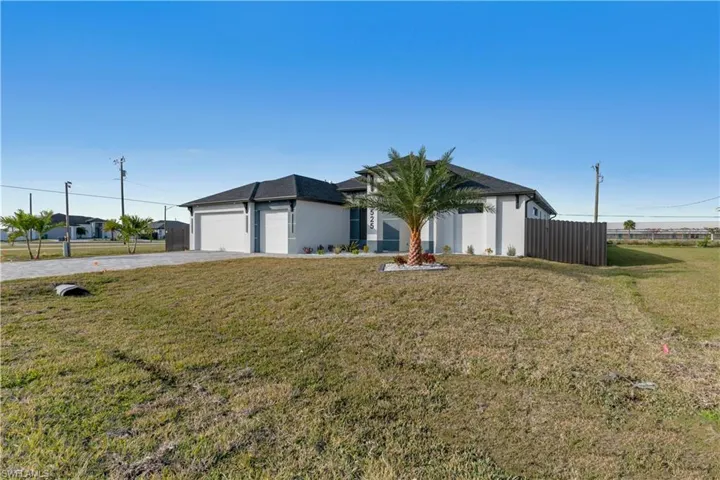 View of front of home with a front yard and a garage