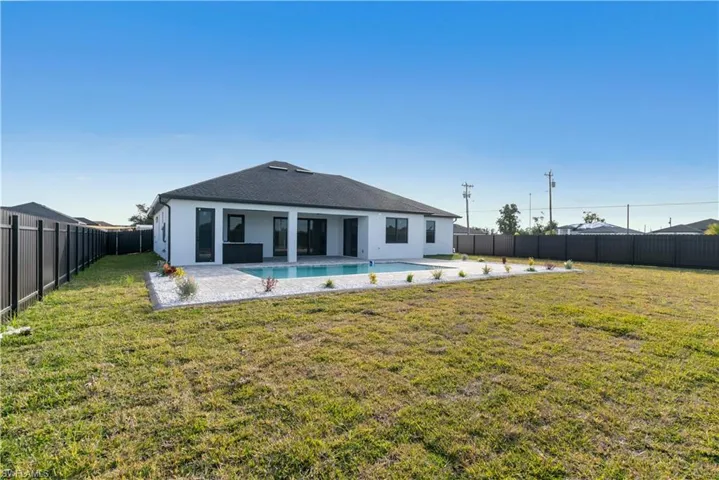 Back of property with a patio and a lawn
