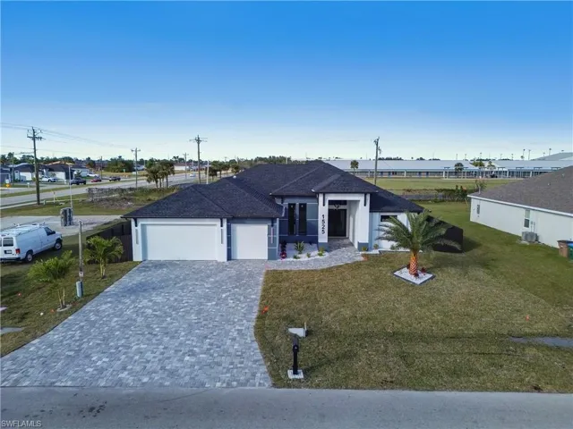 View of front of house with a front yard, a garage, and central air condition unit