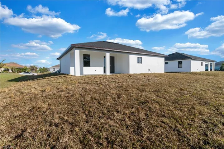 Back of property featuring a lawn