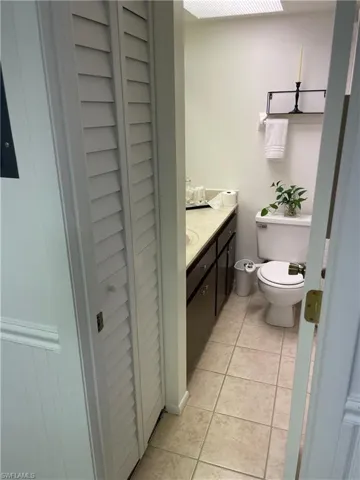 Bathroom with vanity, a closet, and light tile patterned floors