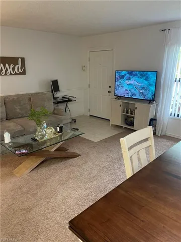 Carpeted living room with a textured ceiling