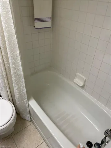Bathroom featuring tile patterned flooring and shower / tub combo