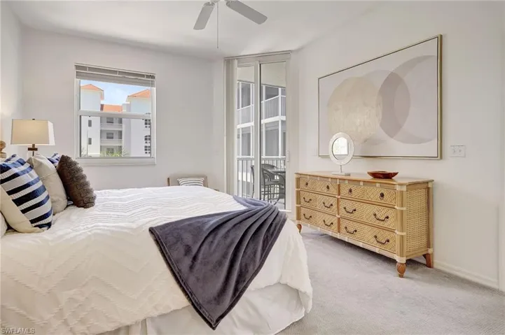 Carpeted bedroom with ceiling fan and access to exterior