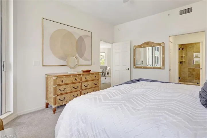 Carpeted bedroom featuring ensuite bath