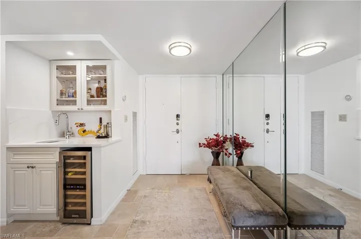 Entrance foyer featuring wine cooler, visible vents, and indoor wet bar