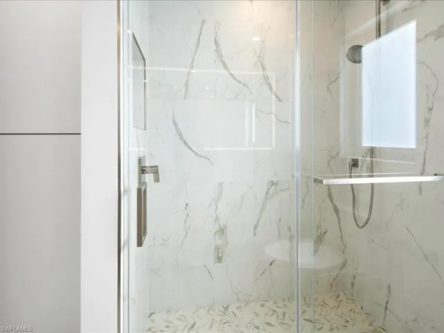 Full bath featuring a marble finish shower