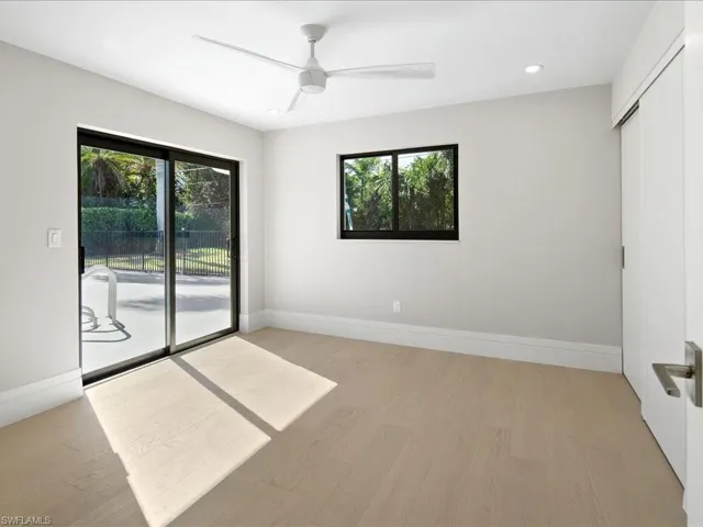 Spare room with a wealth of natural light, baseboards, and light wood finished floors