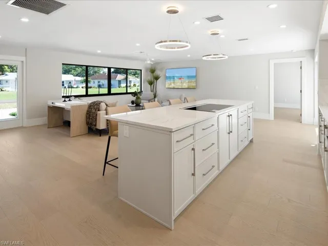 Kitchen featuring a wealth of natural light, visible vents, light wood finished floors, and a center island