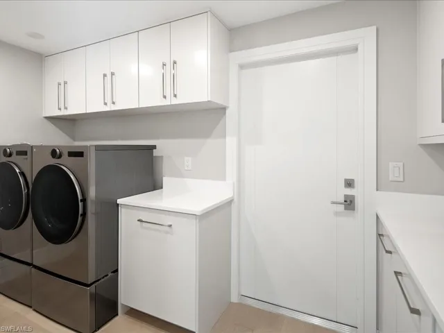 Laundry area with cabinet space and washing machine and dryer
