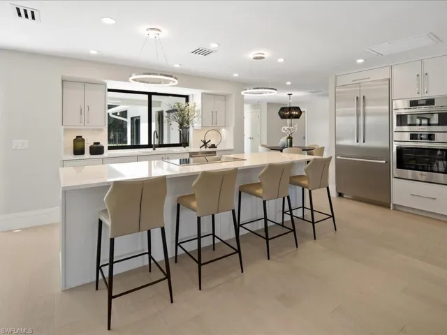 Kitchen with stainless steel appliances, visible vents, a center island, and hanging light fixtures