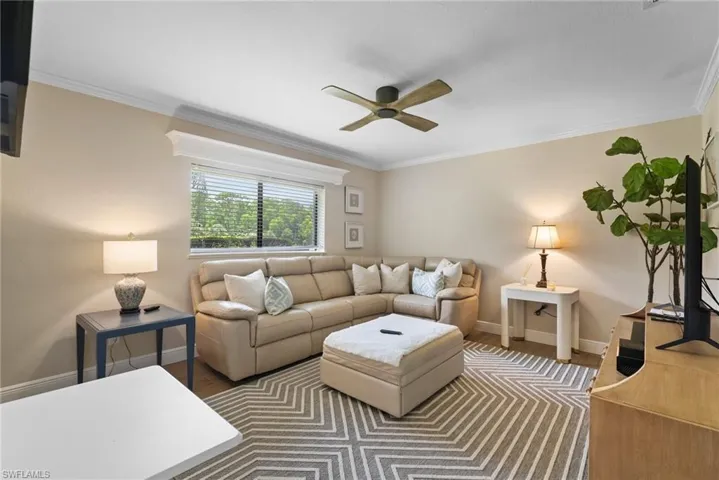 Living room featuring ceiling fan, ornamental molding, and hardwood / wood-style flooring
