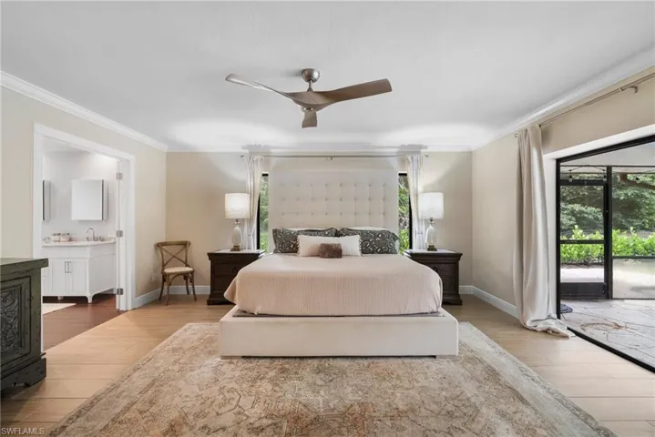 Bedroom featuring ensuite bath, light wood-type flooring, access to exterior, ceiling fan, and ornamental molding