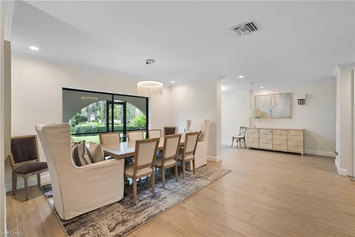 Dining space featuring a chandelier, light hardwood / wood-style floors, and ornamental molding