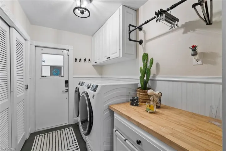 Clothes washing area featuring cabinets, independent washer and dryer, and tile patterned flooring