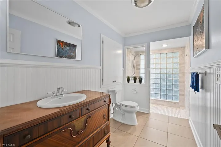 Bathroom featuring tile patterned flooring, plenty of natural light, toilet, and vanity
