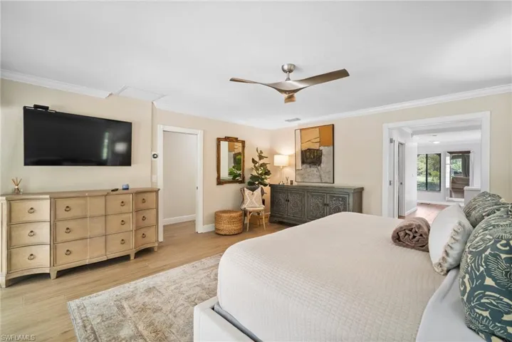 Bedroom with crown molding, light hardwood / wood-style flooring, and ceiling fan