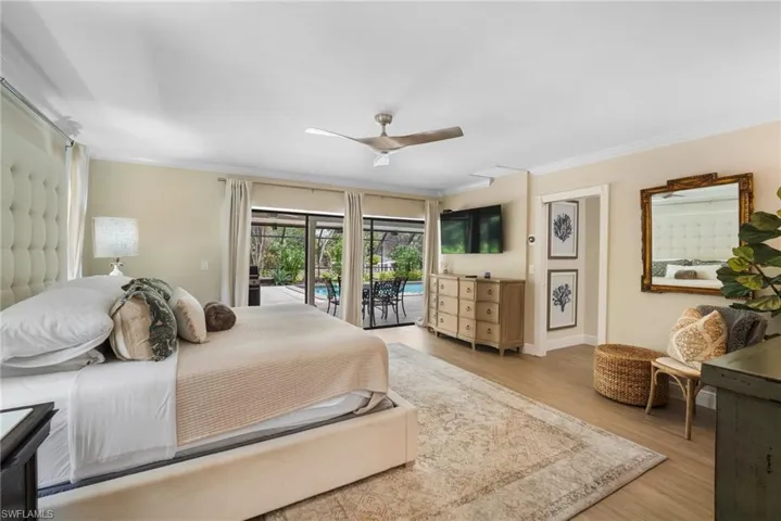 Bedroom with light wood-type flooring, ceiling fan, access to outside, and ornamental molding
