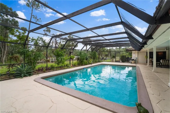 View of swimming pool with a lanai, ceiling fan, and a patio