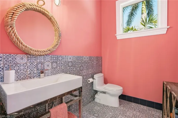 The pool bath offers a playful yet sophisticated powder room with coastal-inspired accents perfect for guests