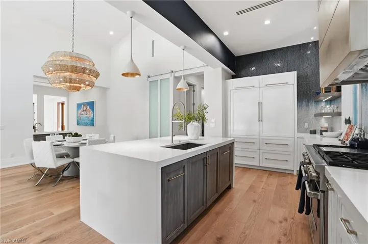 A Chef’s kitchen featuring Wolf and Sub-Zero appliances, custom cabinetry, and a waterfall island