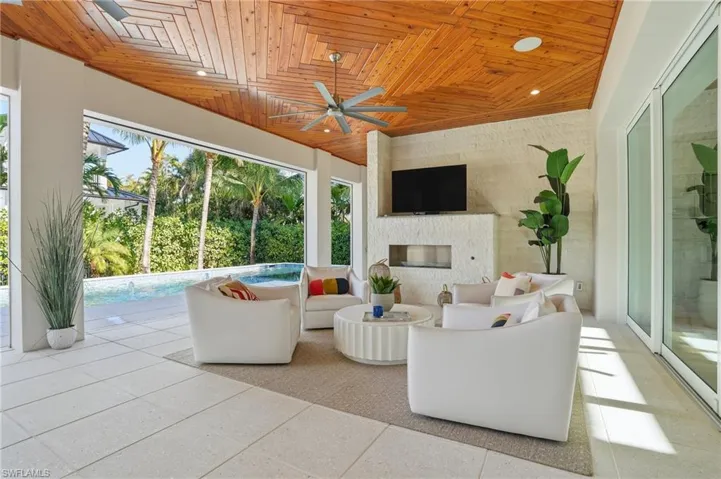 Resort-style outdoor living with a gas fireplace and seamless flow to the pool for year-round relaxation