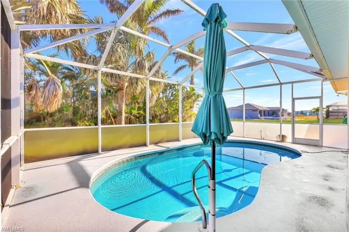 Outdoor pool featuring glass enclosure and a patio area