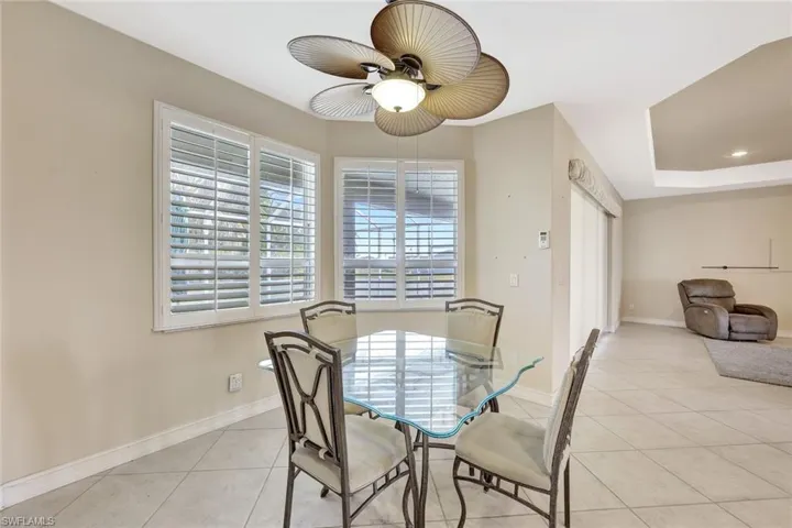 Dining area with baseboards, a ceiling fan, and light tile patterned floors