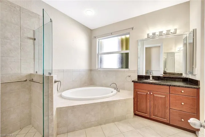 Full bathroom with tile patterned floors, a shower stall, and a bath